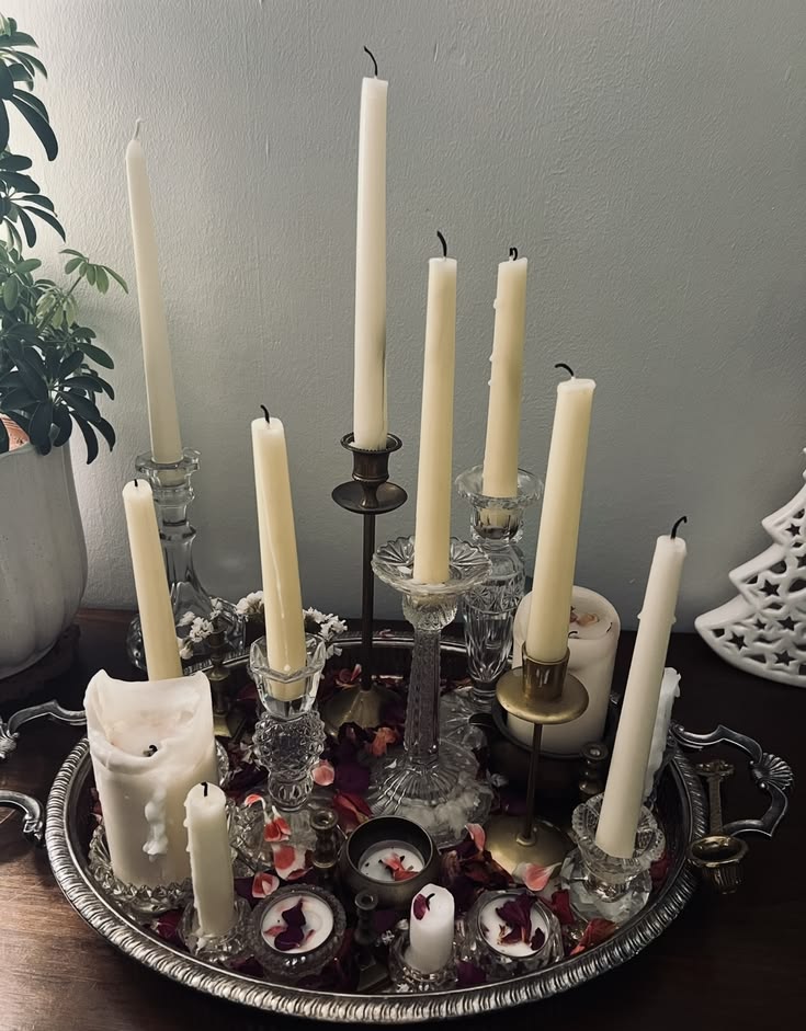 Collection of white taper candles in vintage glass and brass candleholders