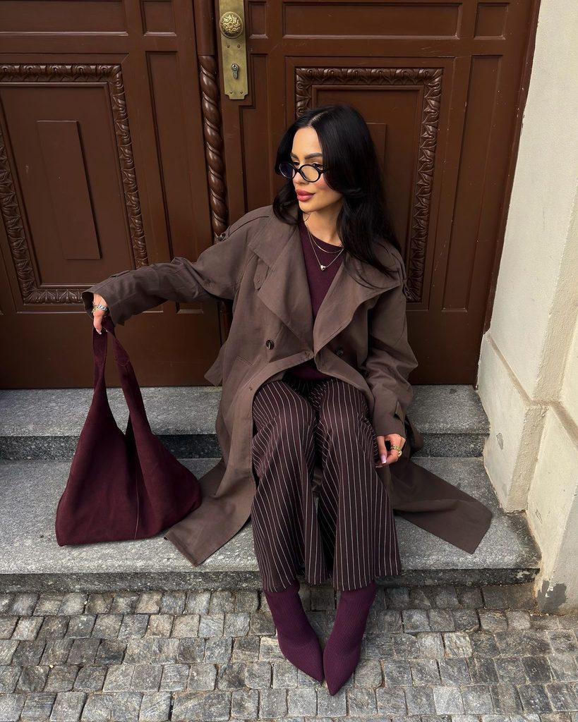 Brown trench coat with burgundy top, pinstripe trousers and burgundy accessories Brown trench coat with burgundy top, pinstripe trousers and burgundy accessories