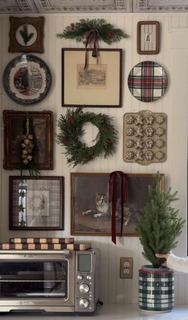 Vintage gallery wall decorated with a small Christmas wreath and seasonal details