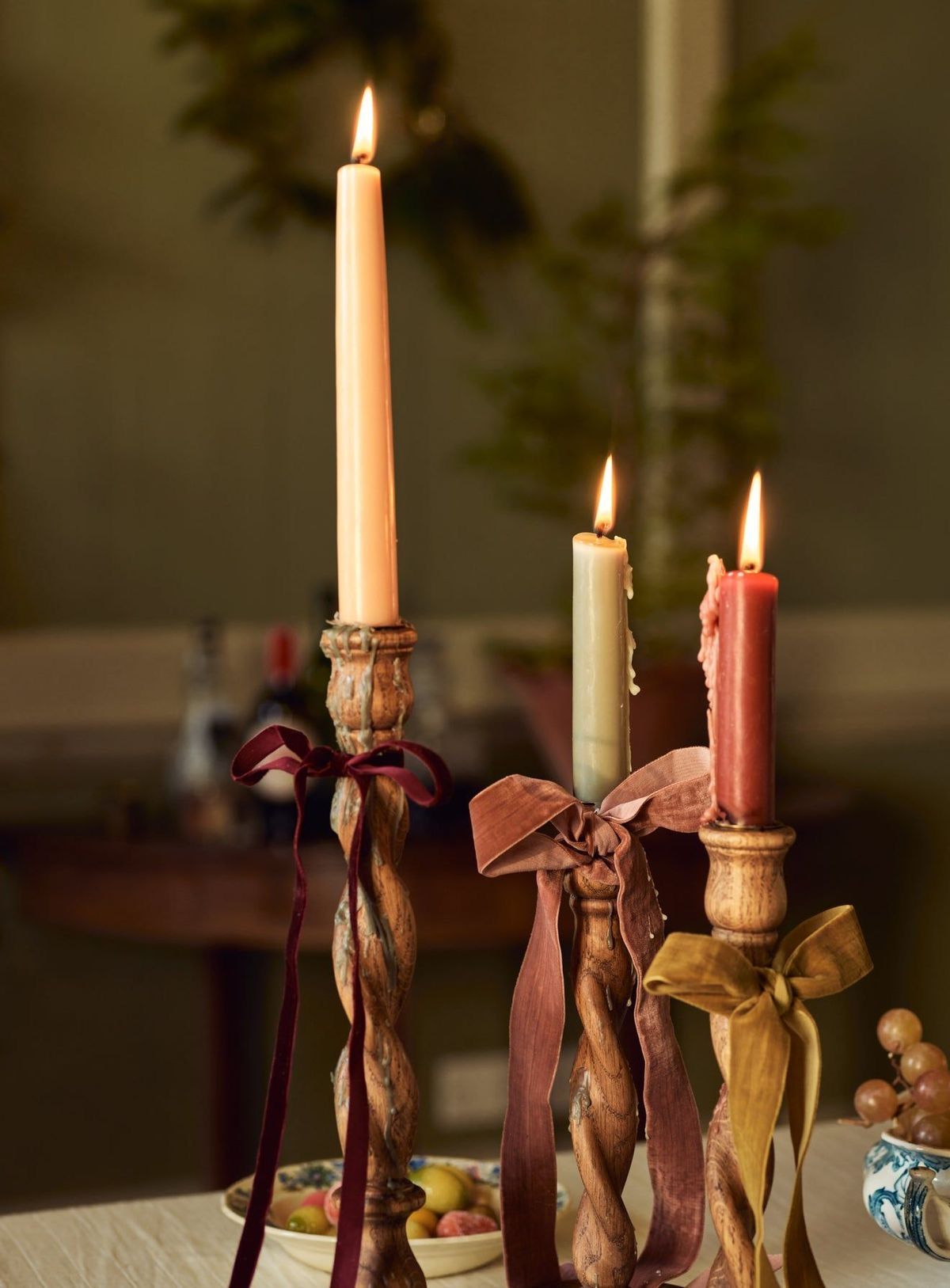 Tall taper candles in vintage candlesticks decorated with velvet ribbons